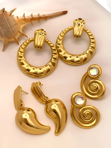 Three pairs of vintage gold earrings with wavy hoops, spiral stones, and teardrop designs