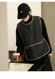 Detail of black waterproof apron showing khaki trim, front pocket, and fashion logo label