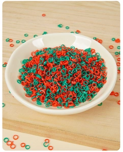 Macro shot of miniature red and green PVC chili rings in a white ceramic bowl