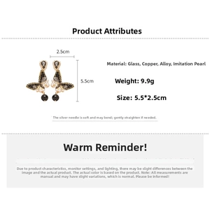 Detail view of butterfly drop earrings with black crystals, imitation pearls, and alloy
