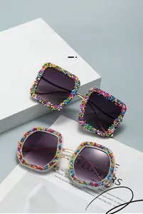 Detail of fashion cat-eye sunglasses with colorful bead decor and gradient lenses