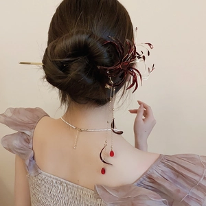 Detail of red Lycoris hair pin with long tassel pendant on traditional hairstyle