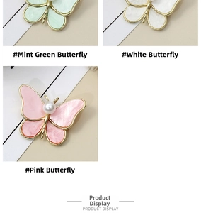 Detailed set of butterfly brooches in mint, white, and pink with pearl center detail