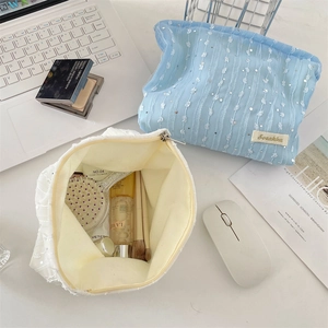 Détail de la trousse à maquillage en maille à paillettes bleues avec fermeture éclair en métal