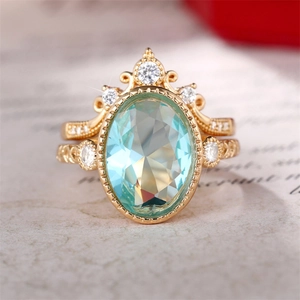 Détail macro de bague couronne avec pierre bleue ovale et filigrane doré