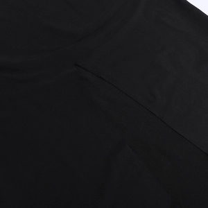 Detailansicht des Schlitzes an einem schwarzen rückenfreien Kleid mit feiner Stofftextur