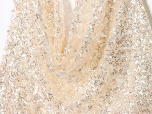 Vue macro détaillée des paillettes argentées champagne sur un tissu en maille