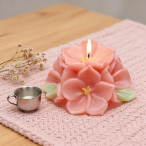 Vela aromática rosa con forma de flor y llama encendida para decoración del hogar