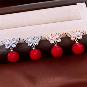 Elegant butterfly earrings with white zircon wings and red round pendant in a gift box