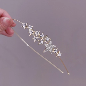 Close-up of golden alloy headband with sparkling zircon stars and central large star detail