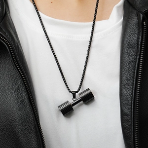 Detail of a black stainless steel dumbbell pendant necklace worn by a male model