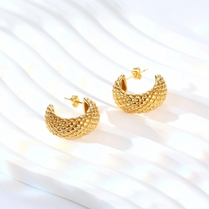 Macro shot of 14K gold plated C-shaped earrings featuring a classic diamond lattice pattern