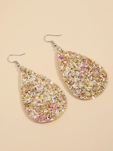Dettaglio di orecchini a goccia con glitter dorati e paillettes rosa su sfondo beige