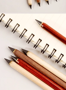 Detailed view of eternal wooden pencils with brass tips on a spiral notebook