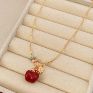Dettaglio macro della collana a mela placcata oro 18k con ciondolo in smalto rosso in scatola