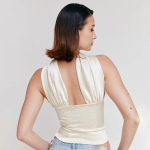Elegante gebroken witte satijnen halter corset top met een open V-hals op de rug