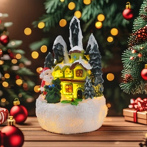 Close-up of lighted resin Christmas house with Santa figure on a cozy wooden table