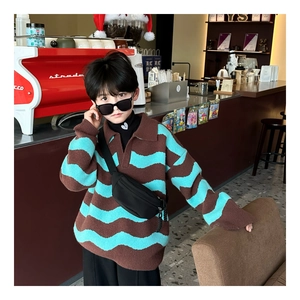 Kids knitted polo shirt with brown and blue stripes styled with a black crossbody waist bag