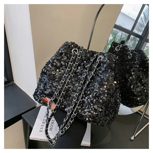Detail of a black sequin bucket bag featuring a drawstring closure and a silver chain strap