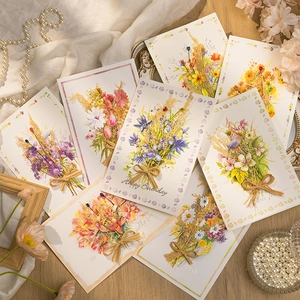 Flat lay of handmade greeting cards with dried flower bouquets and decorative pearls