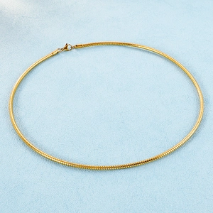 Detail showing the intricate gold snake bone weave texture on a round choker necklace