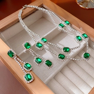 Detailed macro of emerald rectangle jewelry set with silver base and pavé diamond stones