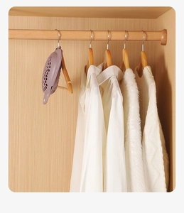 Purple hanging scented closet deodorizer on wooden bar with white clothes in a wardrobe