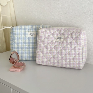 Macro detail of quilted cotton makeup bags with diamond texture and zipper closure