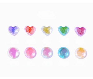 Macro detail of heart and round aurora nail art rhinestones in candy neon colors