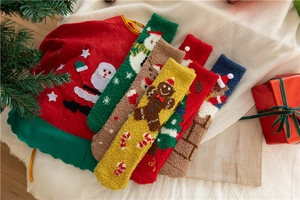 Close-up of soft coral fleece Christmas socks with festive patterns and holiday decor