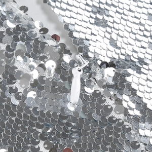 Detailed macro shot of the white invisible zipper on this silver sequin evening gown