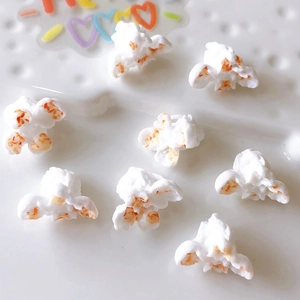 Detailed close-up of resin popcorn charms for DIY jewelry and crafts with caramel spots