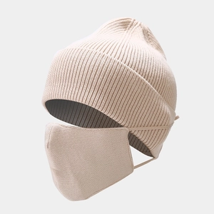 Detail of beige knitted beanie and matching warm mask set with soft ribbed texture