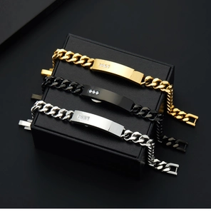 Detailed view of three stainless steel Cuban bracelets in gold, black, and silver on gift box