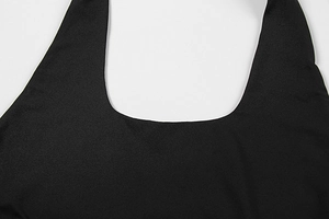Detailed close-up of the black elastic knit fabric and seamless stitching on the dress