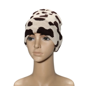 Winter knitted beanie with cow print pattern in beige and brown with rolled cuff