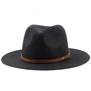 Close-up of black Panama hat texture with brown faux leather belt and gold studs