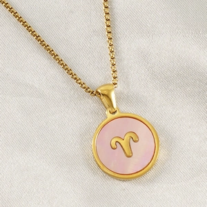 Macro shot of 18K gold plated Aries constellation pendant with pink shell inlay