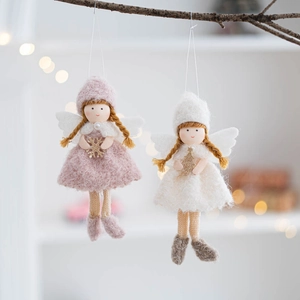 Detail of pink and white felt Christmas angel ornaments with sequins on a festive branch