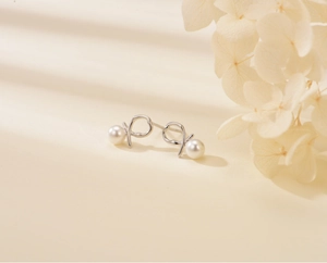 Detailed macro view of S925 silver twist knot stud earring featuring a white pearl accent
