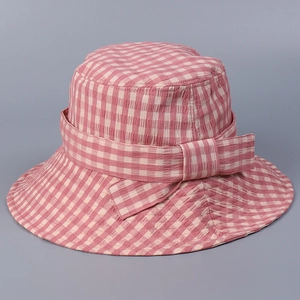 Detail of pink gingham bucket hat with a stylish bow tie and breathable cotton texture