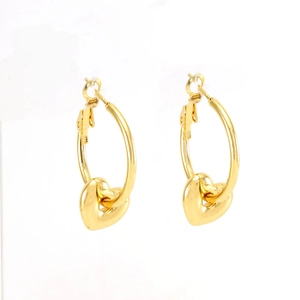 Detail shot of golden heart pendant hoop earrings with polished metallic luster finish