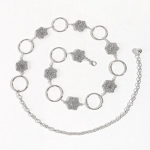 Silver metal chain belt with hollow floral charms and round links on white texture