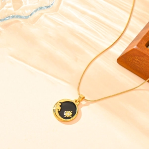 Détail du pendentif lune et soleil doré avec émail noir et cristal sur chaîne serpent fine