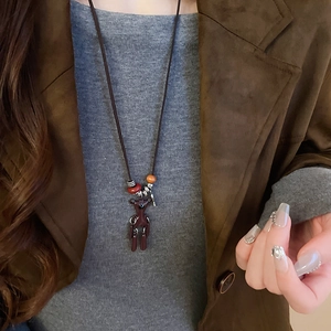 Detail of cute long-legged bear pendant necklace with colorful beads on a model