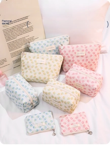 Detailed set of floral lace makeup bags with golden shell zippers in blue, yellow and pink
