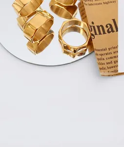 Detailed view of geometric hexagonal gold rings set on vintage newspaper background