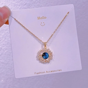 Dettaglio della collana pianeta dorata con pietra cosmica blu e zirconi bianchi