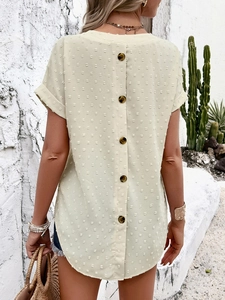 Detail of V-neck top showing back decorative brown buttons and Swiss dot fabric texture