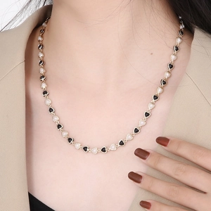 Chic black and white heart necklace with golden beads for a minimalist choker look